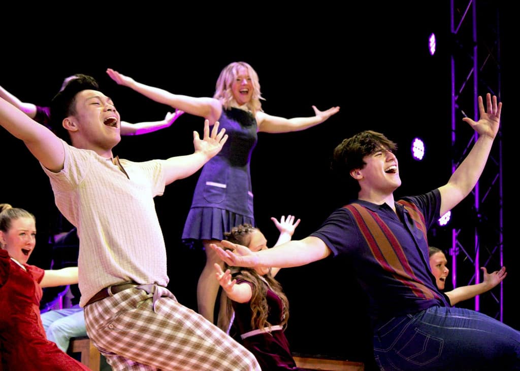 Students from Waukee Community School District sing on stage