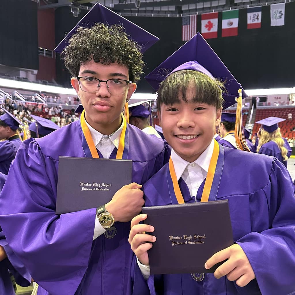 Two Waukee students in purple caps and gowns at graduation
